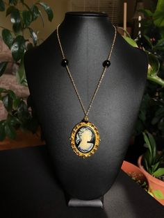 Handmade replica of Shilo Wallace's necklace from 'Repo The Genetic Opera.' Materials: - Gold colored chain.  - Black beads. - Gold colored cabochon setting.  - Lady with ponytail cameo cabochon.  - Gold colored lobster claw clasp. - Gold colored jump rings.  - Epoxy glue.  Measurements: - Necklace length: 18 inches.  - Pendant width: 2 inches.  - Pendant height: 2.5 inches.  Shipping information:  Shipping to Canada Standard shipping:  - No tracking number. -  approximately 2-3 weeks. Xpresspos Vintage Black Medallion Jewelry, Vintage Black Medallion Necklace, Vintage Black Necklace With Adjustable Chain, Vintage Black Chain Necklace With Adjustable Chain, Antique Cabochon Necklace With Round Pendant, Black Round Pendant Necklace Collectible, Antique Cabochon Round Pendant Necklace, Vintage Black Cabochon Necklace, Vintage Black Jewelry For Collectors