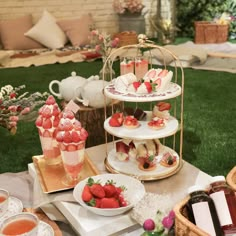 a table topped with cakes and desserts on top of trays next to drinks