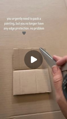 someone is cutting out a piece of cardboard with scissors