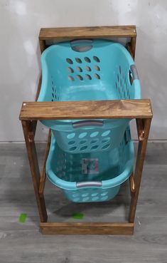 a blue laundry basket sitting on top of a wooden stand