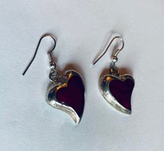 "This is a pair of heart-shaped sterling silver (.925) red dangle/drop earrings. Material(s): Sterling Silver (.925) + red stone (the photos make the heart appear black, but they are a dark red) Total weight: 6.2 grams Flaws (if any): None to mention Marking(s): \".925\" (translating to \"sterling silver\") Measurements: The drop length of these earrings is 1 and 3/8 inches. The width of these earrings is 3/4 of an inch, at their widest point. If you have any questions about this pair of earring Valentine's Day Gift Earrings With Polished Finish, Red Sterling Silver Pierced Heart Earrings, Sterling Silver Heart Earrings With Polished Finish, Red Polished Earrings For Gift, Red Sterling Silver Dangle Heart Earrings, Handmade Red Heart Earrings In Sterling Silver, Handmade Red Heart Sterling Silver Earrings, Vintage Red Heart Earrings For Gift, Vintage Red Heart Earrings As Gift