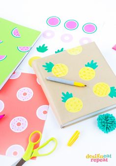 a notebook with pineapples on it next to scissors and other crafting supplies