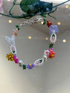 This beautiful  multi color flowers bracelet is handmade. Would be a great gift for her, a wedding gift, Christmas gift, and more, z You can make them into matching bridesmaid, bracelets, party favors, and just an every day accessory. If you would like I can customize any colors on the bracelet just send me a message. I offer lengths 5 inches to 9 inches. If you need another size, please let me know and I would love to make it for you. If you do not like the clasp I have other options just let me know when I can send you some pictures. This product is fully customizable at no additional cost. If you have any questions about this item, please let me know and feel free to message me. Dainty Flower Bracelets For Party, Handmade Dainty Flower Beaded Bracelets, Spring Gift Beaded Necklaces With Tiny Beads, Spring Gift Beaded Necklace With Tiny Beads, Dainty Flower-shaped Bracelet With Colorful Beads, Dainty Beaded Flower Jewelry, Dainty Flower-shaped Beaded Jewelry, Spring Flower Charm Beaded Necklace As Gift, Spring Flower Charm Bracelet Gift