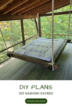 a bed frame hanging from the ceiling in a room with wood flooring and windows