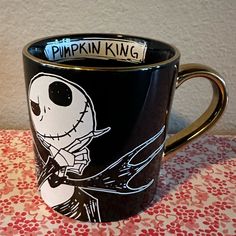 a black coffee cup with a skeleton on it