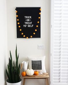 a white room with a black and orange trick or treat sign hanging on the wall