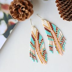 These perfectly joyful and beautiful unique earrings are the perfect way to show off your love of the harvest season. An unexpected combination of pearl, maize, peach, brown and turquoise this pair is reminiscent of flint corn and brings all the fall vibes. Beautiful on any skin tone or hair color. Details: Handcrafted by artisans in Medellin, ColombiaMaterials: Seed beads, stainless steel hardware for comfort and longevitySize: Approximately 3.5 inches from top of hook, 1 inch wideSKU: E1144 FO Flint Corn, Earring Inspired, Diy Jewelry Earrings, Stitch Earrings, Bead Earring, Brick Stitch Earrings, Beaded Earring, Harvest Season, Beading Ideas