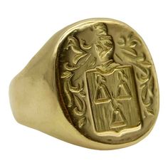 This 18k gold Tiffany & Co. Larter & Sons signet ring is hand carved with a heraldic family crest. The crest has a shield with three bell-like shapes sprouting flowers. Above the shield is a knight’s helmet topped with a feather and surrounded by scrolling foliate. The classic design of the crest suggests royalty and valor.  Larter & Sons was founded in 1865 and was renowned for their exquisite craftsmanship of men’s accessories. They expanded to include women’s jewelry in the early 20th century, using intricate techniques such as guilloche and enamelwork, and incorporating motifs inspired by nature. They collaborated with Tiffany & Co. to make jewelry such as cufflinks and signet rings. Tiffany & Co. would often consign well-known brands of the highest quality, including Larter & Sons. Symbolic Hallmarked Signet Ring For Formal Occasions, Symbolic Formal Signet Ring Hallmarked, Formal Symbolic Hallmarked Signet Ring, Luxury Carved Yellow Gold Signet Ring, Classic Yellow Gold Engraved Ring With Coat Of Arms, Classic Ceremonial Engraved Intaglio Ring, Gold Oval Signet Ring With Coat Of Arms, Classic Yellow Gold Signet Ring With Intaglio, Formal Gold Signet Ring With Coat Of Arms