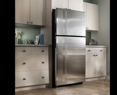 a metallic refrigerator freezer sitting in a kitchen next to white cupboards and drawers