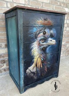 an artistic painted cabinet on the side of a building with a bird's head