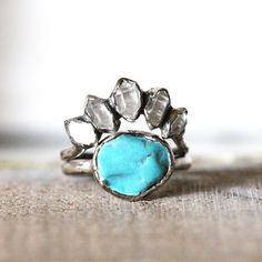 a turquoise stone ring sitting on top of a wooden table