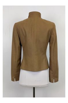 This tailored blazer is made in a rich tan color. Designed with a stand up collar and dark gold rounded buttons. It can be paired with fitted skirts or trousers. Size 6 60% wool, 40% angora Made in Switzerland Button down Dark gold buttons Stand Up collar Zip Up pockets Bust 36" Waist 32.5" Shoulder to hem 21.5" Brown Stand Collar Blazer With Buttons, Brown Blazer With Stand Collar And Buttons, Semi-formal Fitted Outerwear With Stand Collar, Fitted Stand Collar Blazer With Buttons, Fitted Brown Blazer With Hidden Button Closure, Fitted Stand Collar Outerwear For Semi-formal Occasions, Fitted Blazer With Stand Collar, Brown Fitted Blazer For Office, Fitted Stand Collar Blazer For Work