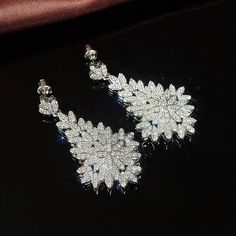 These stunning Barbie Brides Luxury Leaf Drop Dangle earrings are perfect for any occasion. Crafted with 18K white gold-plated copper and adorned with excellent cut grade cubic zirconia stones, these earrings are a true work of art. The silver-colored stones add an element of timeless elegance to any outfit, while the dangle/drop style makes them perfect for a night out or a special event. These earrings are not only beautiful, but also feature nickel-free materials, making them safe for even the most sensitive ears. Whether it's for an engagement, wedding, anniversary, Valentine's Day, Mother's Day, graduation, or birthday, these earrings make the perfect gift. Add a touch of beauty, luck, love, and fantasy to any outfit with these stunning earrings. Cubic Zirconia Bridal Earrings, Jewelry 2022, Barbie Bride, Craft Packaging, Big Leaves, Writing Gifts, Cz Jewelry, Earrings Women, Trendy Earrings