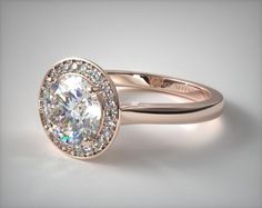 a gold ring with an oval cut diamond surrounded by smaller round diamonds on the band