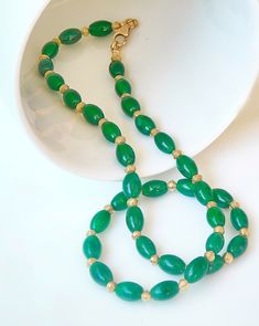 Elegant beaded necklace made with green onyx barrel beads (6x9mm) and 24k gold vermeil curled ribbon spacer beads (4x3.5mm). The single strand necklace is 18 inches long and closes with a 14k gold filled lobster claw clasp. Please message me if you would prefer a gold filled toggle clasp instead. I use only the best beading wire available for maximum flexibility and strength and crimp the ends for extra security. See more of my necklace designs at https://www.etsy.com/shop/JenniferMarcusDesign?ref=profile_header Gold Jade Beaded Necklaces With Round Beads, Gold Jade Round Beaded Necklaces, Gold Jade Necklaces With Polished Beads, Elegant Gold Beaded Necklaces With Green Onyx, Elegant Gold Beaded Necklace With Green Onyx, Elegant Green Onyx Beaded Necklaces, Elegant Green Oval Bead Necklaces, Elegant Green Necklaces With Oval Beads, Gold Emerald Necklace With Green Onyx Round Beads