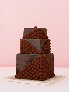 a three tiered cake with chocolate balls on top