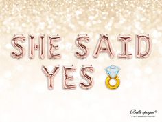 the words she said yes are made out of foil balloons and gold rings on a white background