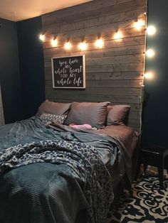 a bed sitting in a bedroom next to a wall with lights on it's headboard