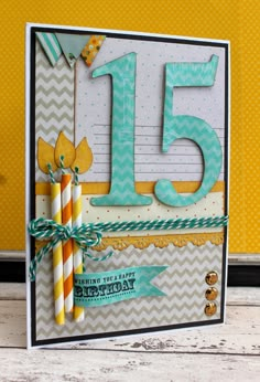 a birthday card with the number fifteen on it and two candles in front of it