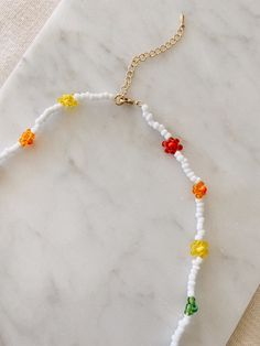 "This hand beaded flower necklace features rainbow or pastel flowers and measures 16\" at its smallest. Necklace is adjustable up to 18\" I love this necklace layered with other gold chains or worn alone to spruce up jeans and a t-shirt. Strung on elastic jewelry string and has a gold plated lobster clasp closure. Message me with any questions!" Adjustable Beaded Necklace With Colorful Beads And Flower Pendant, Adjustable Flower Necklace With Round Beads For Spring, Trendy Adjustable Beaded Flower Necklace, Trendy Adjustable Flower Necklace With Colorful Beads, Colorful Beads Adjustable Necklaces For Spring, Adjustable Tiny Beads Necklace For Spring, Rainbow Jewelry With Colorful Beads For Spring, Spring Adjustable Tiny Beads Necklace, Multicolor Adjustable Beaded Necklaces With Flower Pendant