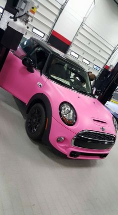 a pink mini cooper parked in a garage