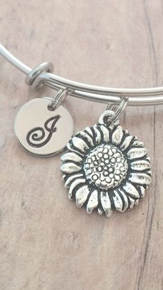 "This listing is for a hand stamped initial bangle featuring a 7/10\" x 3/5\" pewter sunflower charm & 2/5\" stainless steel initial pendant. The stainless steel bangle measures 65mm (2.5\") in diameter and fits most adult women's wrists. All items are lead & nickel free. Please message me with any questions, thank you! Add an initial to any item: https://www.etsy.com/listing/170461597/add-an-initial?ref=shop_home_active&ga_search_query=Add Add a birthstone to any item: https://www.e Silver Flower Jewelry For Friendship, Silver Bracelets With Flower Charm, Silver Flower Jewelry For Everyday Wear, Silver Personalized Flower Bracelet, Personalized Silver Flower Bracelet, Personalized Silver Flower Bracelets, Personalized Flower Jewelry For Friendship, Personalized Flower-shaped Jewelry For Friendship, Personalized Flower Shaped Friendship Jewelry