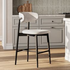 a white counter top sitting next to a wooden floor in a kitchen with gray cabinets