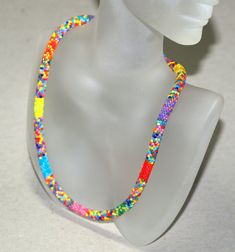 a white mannequin with a multicolored necklace on it's head