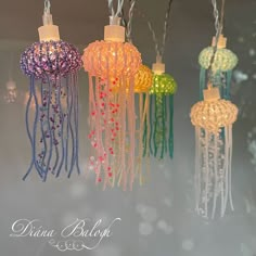 several different colored lights hanging from strings