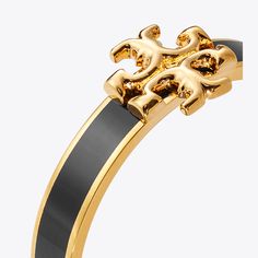 The Kira ring pairs smooth enamel with our signature Double T. It is a subtle statement on its own or worn with the Kira Enamel Bracelet. Elegant Adjustable Gold Enamel Ring, Elegant Black Enamel Ring, Elegant Adjustable Enamel Jewelry, Elegant Formal Enamel Ring, Classic Gold Enamel Ring, Classic Black Enamel Bangle Jewelry, Classic Black Enamel Bangle, Modern Polished Enamel Ring, Tory Burch Ring