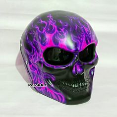 a purple and black skull with flames on it