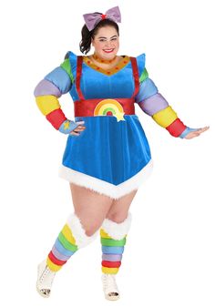 a woman dressed in a rainbow costume posing for the camera with her arms out and legs crossed