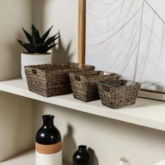 three baskets are sitting on a shelf next to a vase