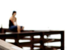 a blurry photo of a person sitting on a pier