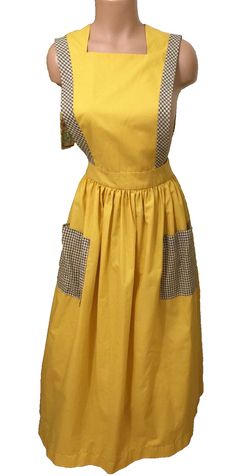 a mannequin wearing a yellow dress with checkered straps and pockets on the chest