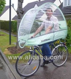 a man riding on the back of a bike with a cover over it