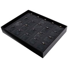 a black box with several pairs of studs and other items in it on a white background