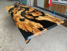 a table made out of wood with black and gold paint on it's surface