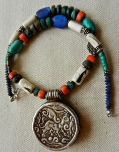 "SALE! Vintage Hand Made Himalayan Necklace With Auspicious Sterling Silver Pendant, Red Coral,Turquoise, Conch Shell, And Lapis Lazuli Was $275.00 Now $199.00 57.5 Grams 16.5\" Long This is a lovely necklace at a great price. A friend has hit hard times and asked me to sell this for them. Himalayan in design with the addition of lapis lazuli. The pendant is hand made with deeply carved designs on the front which are quite stylized and difficult for me to identify. There is a single piece of nat Traditional Handmade Turquoise Necklace, Traditional Multicolor Turquoise Necklace For Festival, Spiritual Multicolor Turquoise Necklace For Festivals, Traditional Turquoise Necklace For Festivals, Traditional Turquoise Necklace For Rituals, Deep River, Carved Designs, Conch Shell, Lovely Necklace