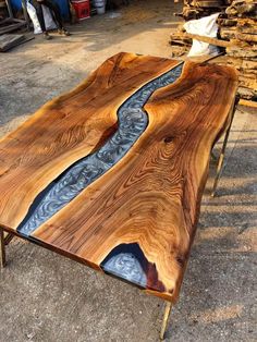 a table made out of wood and metal with a river running through the center, on top of it