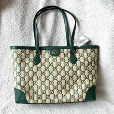 Typically Crafted In The Brand's Monogram Canvas, This Iteration Of Gucci's Famed Ophidia Tote Bag Feels Natural In Its Neutral Straw Construction With The Interlocking G Motif Woven In A Striking Green Hue. Outer: Straw 100%, Leather 100% Product Measurements Depth 5.5 In Handle 10 In Height 11 In Strap 21 In Width 15 In Made In Italy Luxury Green Bags For Errands, Green Luxury Bag For Errands, High-end Green Bags For Shopping, High-end Green Shopping Bag, High-end Green Tote Bag, Luxury Green Shopping Bag, Luxury Green Shoulder Bag With Double Handle, Designer Green Shopping Bag, Designer Green Bag For Shopping