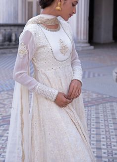 This look features an ivory anarkali set. The closed neck, full sleeves set has a yoke with an embroidered motif and a flowy ghera. Inspired by the royal palaces, it is embellished with mirror, threadwork, pearls, zardozi and sequins all over. A matching net dupatta with scallop border and bootis completes the look. Composition: Anarkali - Viscose georgette, Dupatta - Soft net, Churidar - Lycra Care: Dry Clean Only and Vacuum Storage This product can be customised for colour, sleeves, length of blouse and neck design Delivery : 2 weeks as the product is hand crafted. For more information and sizes please contact fabiliciousfashion@gmail.com or visit our Copenhagen studio.About the Designer : Renee Label was created in 2013,by the talented sister duo Pooja and Karuna, is a culmination of th Ivory Anarkali, Scallop Border, Royal Palaces, Georgette Dupatta, Add Sleeves, Indian Couture, Net Dupatta, Thread Work, Churidar