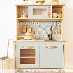 a wooden toy kitchen with lots of items on the shelves and cupboards above it