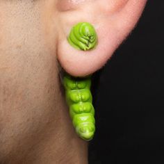 a close up of a person's ear with green beads