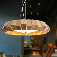 a wooden chandelier hanging over a dining room table with bowls and plates on it