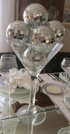 the table is set with wine glasses, plates and silverware in front of a mirror