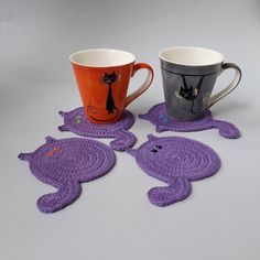 two mugs and one elephant are sitting on the table with crocheted coasters