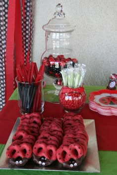 a table topped with lots of red cookies covered in chocolate