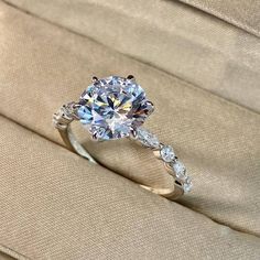 a diamond ring sitting on top of a cushion