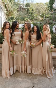 a group of women standing next to each other in long brown dresses and holding bouquets